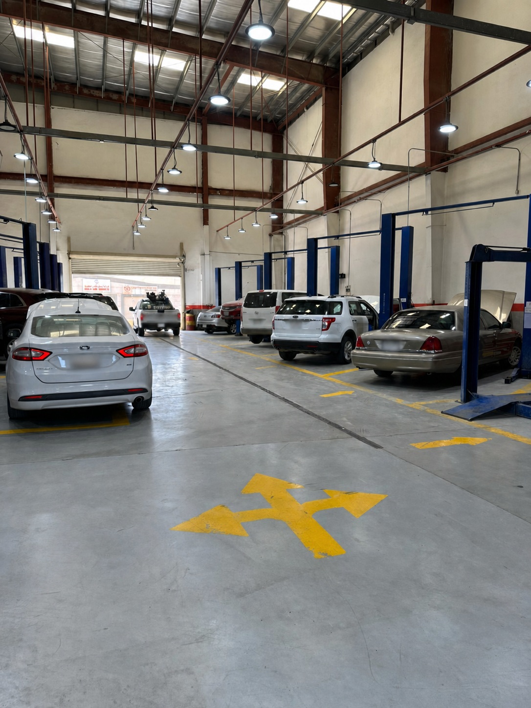 Automotive workshop service bay with multiple repair stations